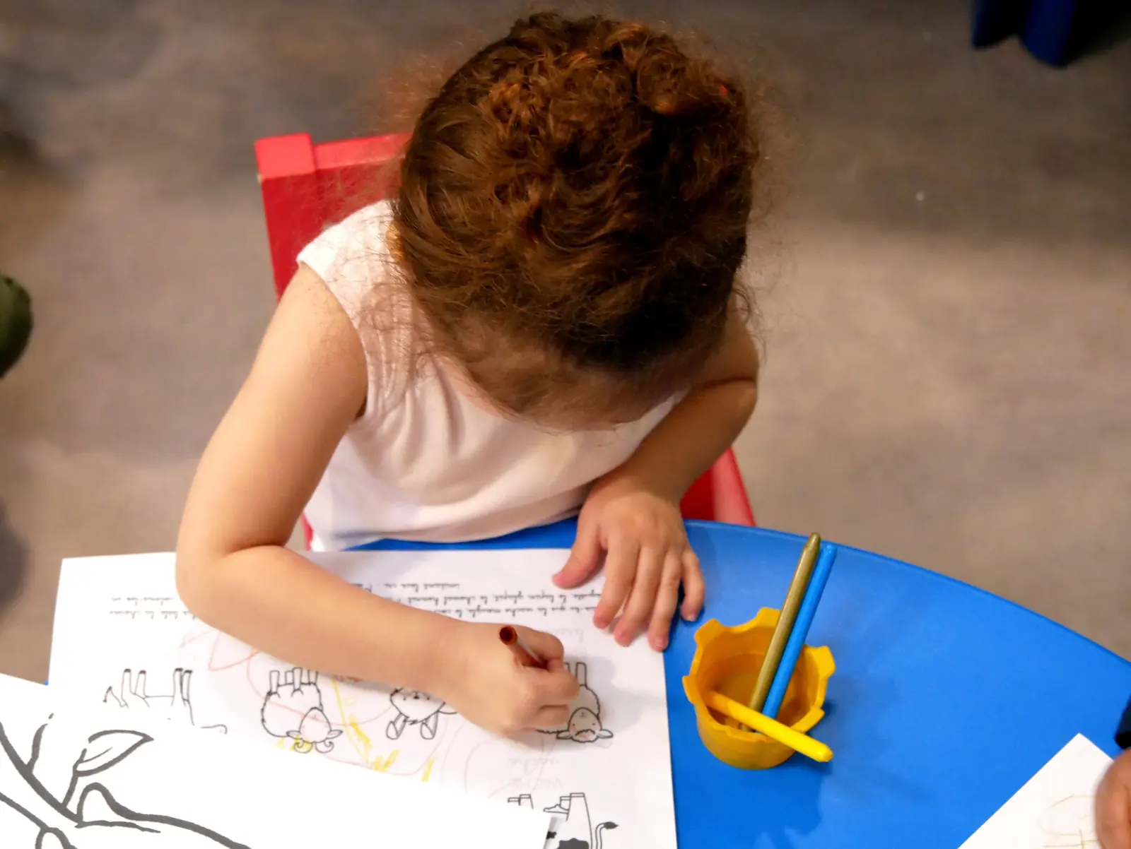Une enfant colorie un dessin à la crèche