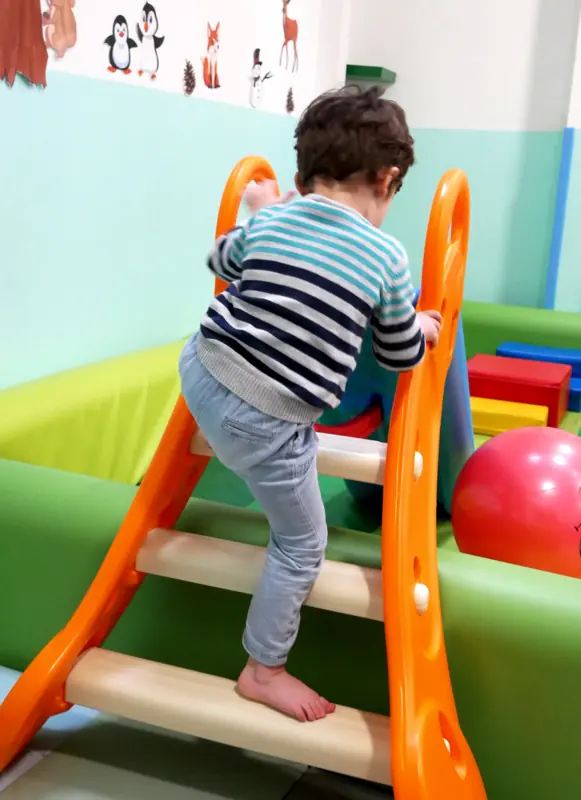 Un enfant grimpe sur le toboggan